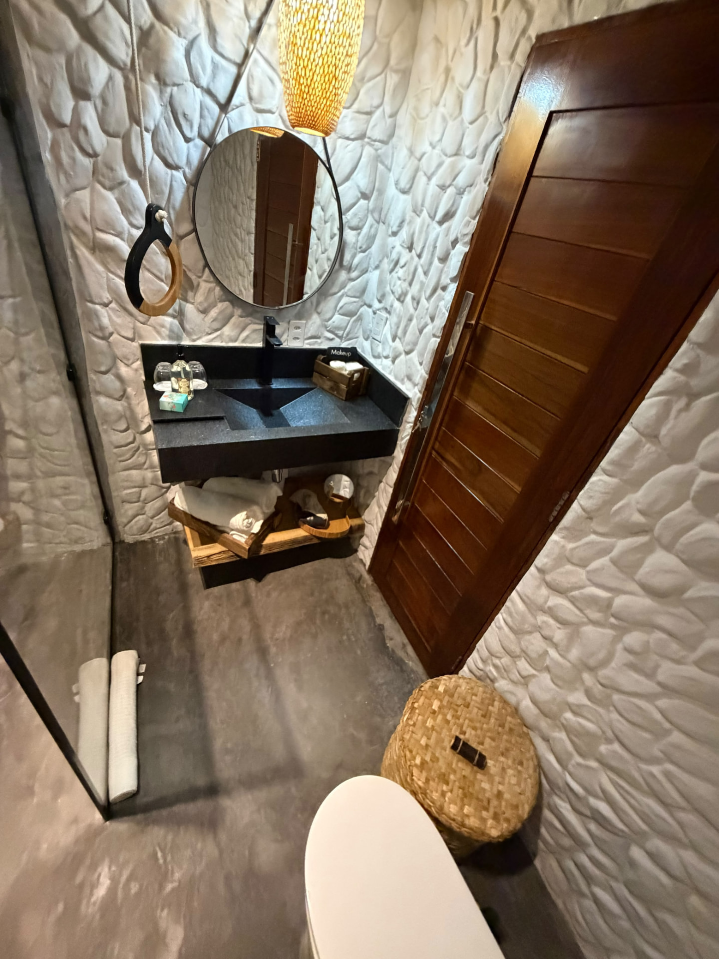 Lavabo com espelho redondo e prateleira de madeira