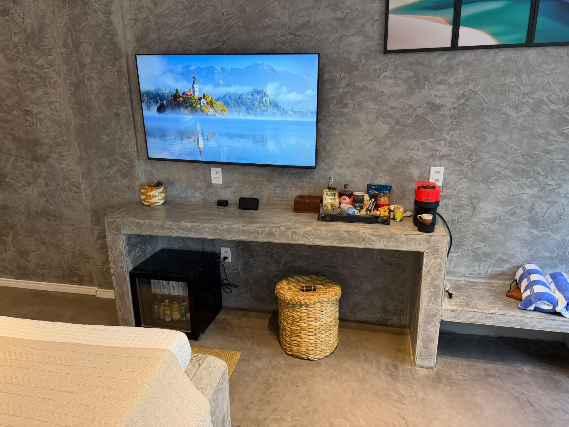 Bancada com TV, frigobar, cafeteira e cesta de boas-vindas